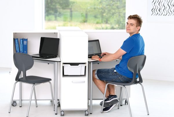 uczeń w sali informatycznej z mobilnymi kontenerkami