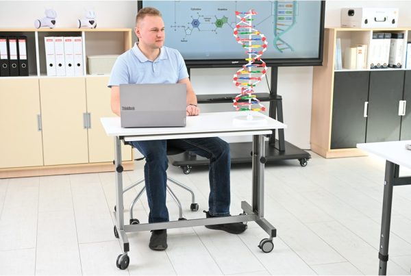 nauczyciel siedzi przy mobilnym biurku