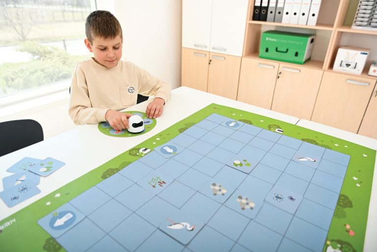 robot loogi mini bot podczas zajec z chlopcem