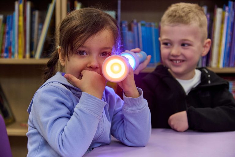 chłopiec i dziewczynka świecą edukacyjnymi latarkami tts