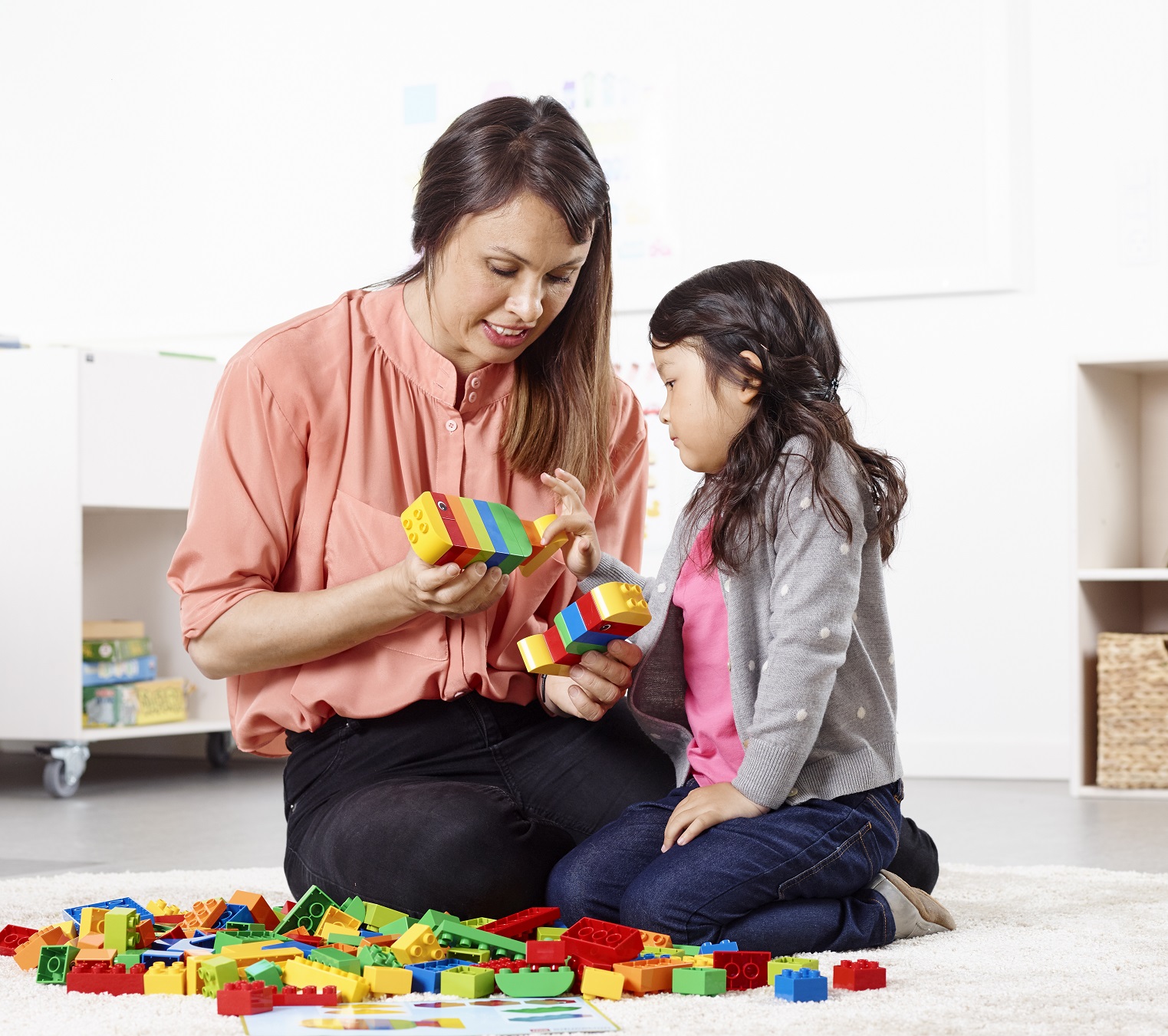 kobieta i dziecko budują model z klocków lego education duplo